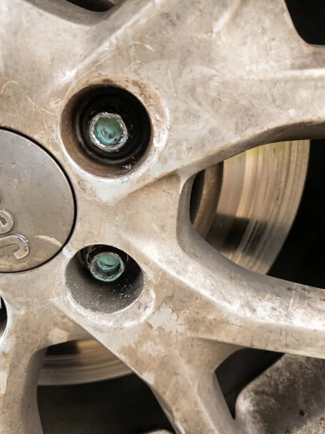 Corroded stripped lug nut being extracted with an impact socket on a mounted wheel — All Hours Roadside, Dallas–Fort Worth