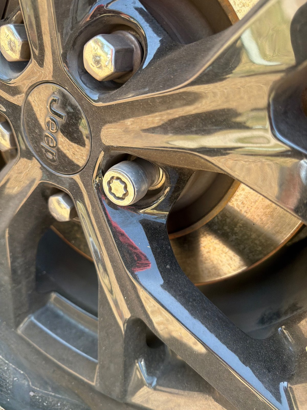 Factory 7-spline wheel lock on a Jeep Cherokee alloy wheel with no key on hand — removed on-site by All Hours Roadside in Austin, TX