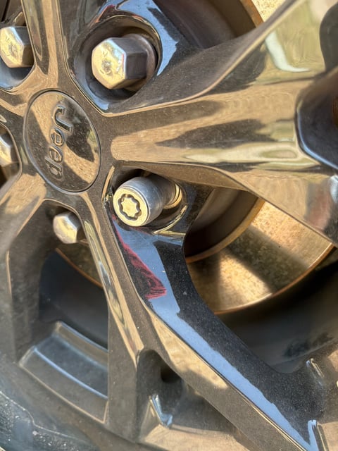 Factory 7-spline wheel lock on a Jeep Cherokee alloy wheel with no key on hand — removed on-site by All Hours Roadside in Austin, TX