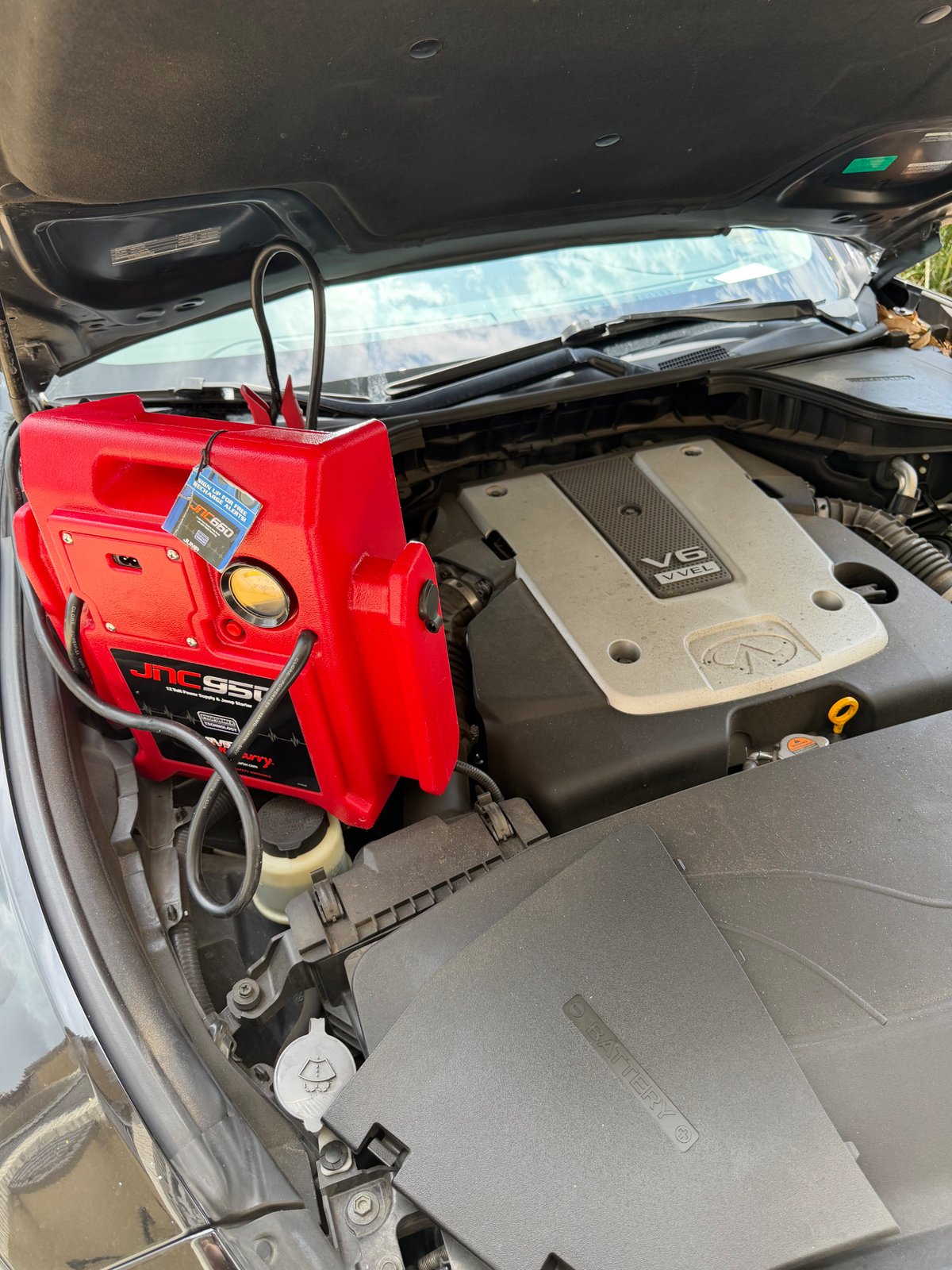 All Hours Roadside JNC950 professional jump-pack clamped to an Infiniti V6 VVEL engine battery in a Fort Worth driveway