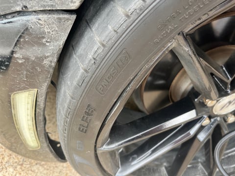 Close-up of Pirelli P-Zero PNCS run-flat tire sidewall showing internal cord damage from pothole impact — All Hours Roadside, DFW
