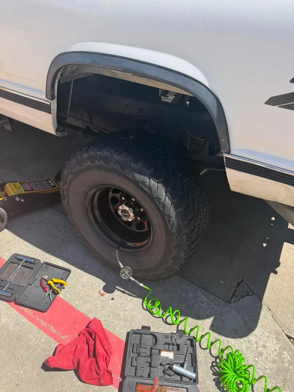 Finished mobile tire repair with tire aired back up and tools packed near the repaired truck tire